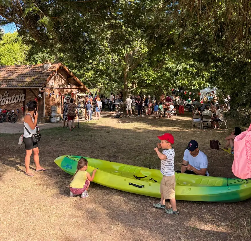 Un kayak posé dans l'herbe devant la cabane du Ponton