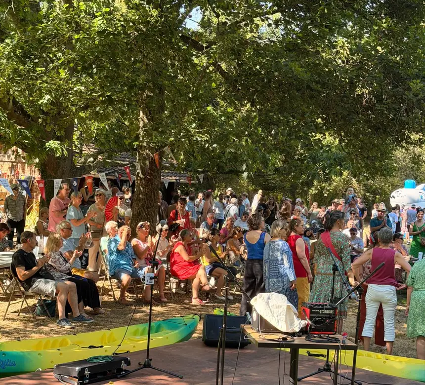 Un groupe en plein air devant le public assis dans l'herbe