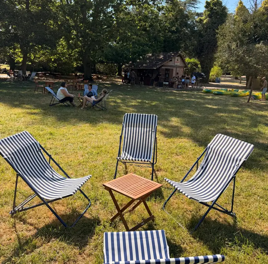 Des transats rayés installés à l'ombre dans le parc